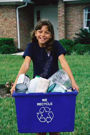 girl carrying recycling bin in front of house